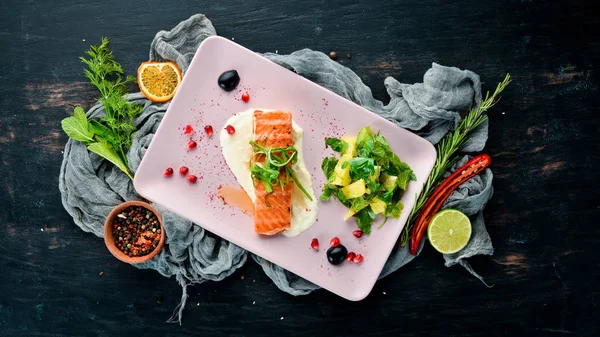 Bir tabakta sebze ile pişmiş somon fileto. Ahşap bir arka plan üzerinde. Üstten Görünüm. Metniniz için boş alan.
