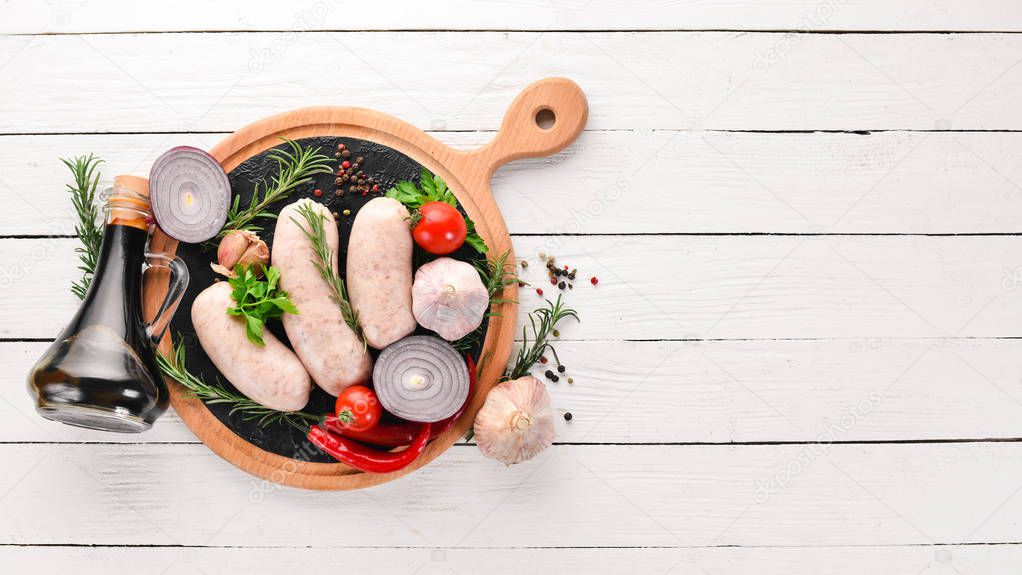 Raw sausages with spices and herbs. Barbecue. On a black stone background. Top view. Free copy space.