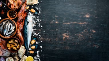 Deniz ürünleri. Taze balık, karides, istiridye ve havyar siyah ahşap zemin. Üstten Görünüm. Ücretsiz kopya alanı.