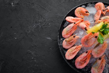 Buz ve limon ile karides. Eski arka planda. Üst görünüm. Ücretsiz kopya alanı