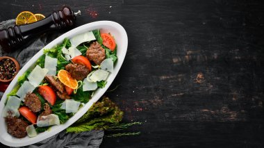 Kaz karaciğeri, ıspanak, domates ve parmesan peyniri ile salata. Ahşap bir arka planda. Üst görünüm. Ücretsiz kopya alanı