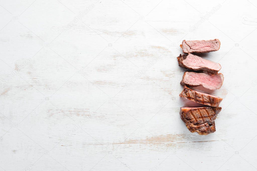 Beef steak. Veal, meat. On a white wooden background. Top view. Free copy space.