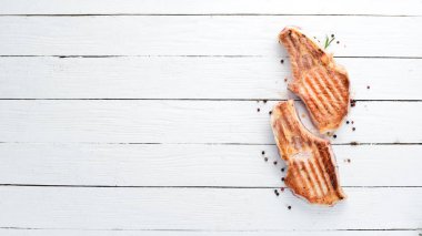 Biberiye ile kemik üzerinde biftekler. Mangal, Barbekü. Siyah taş arka planda. Üst görünüm. Ücretsiz kopya alanı.