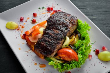 Bir tabak sebze üzerinde dana eti. Ahşap bir arka planda. Üst görünüm. Metniniz için boş alan.