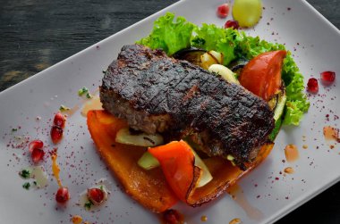 Bir tabak sebze üzerinde dana eti. Ahşap bir arka planda. Üst görünüm. Metniniz için boş alan.