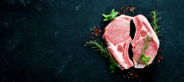 Kemikte çiğ biftek. Baharat ve otlar ile et. Beyaz ahşap bir arka planda. Üst görünüm. Ücretsiz kopya alanı.