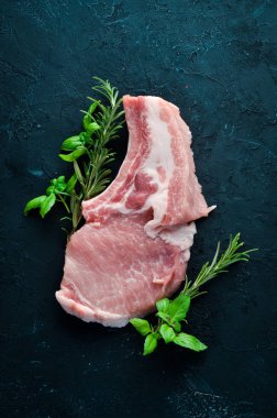 Kemikte çiğ biftek. Baharat ve otlar ile et. Beyaz ahşap bir arka planda. Üst görünüm. Ücretsiz kopya alanı.