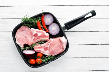 Kemikte çiğ biftek. Baharat ve otlar ile et. Beyaz ahşap bir arka planda. Üst görünüm. Ücretsiz kopya alanı.