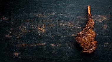 Kemik üzerinde biftek. Tomahawk biftek siyah ahşap arka planda. Üst görünüm. Ücretsiz kopya alanı.