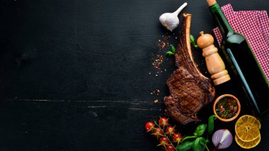 Kemik üzerinde biftek. Tomahawk biftek siyah ahşap arka planda. Üst görünüm. Ücretsiz kopya alanı.