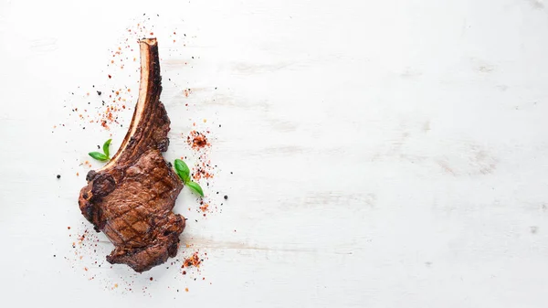肉を骨に黒い木製の背景にトマホークステーキ トップビュー フリーコピースペース — ストック写真