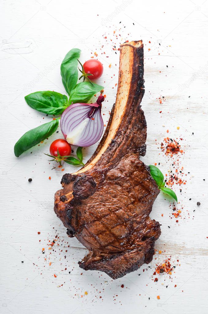 Steak on the bone. tomahawk steak On a black wooden background. Top view. Free copy space.