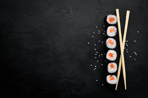 寿司卷生三文鱼 日本料理 顶部视图 在黑色的石头背景上 — 图库照片