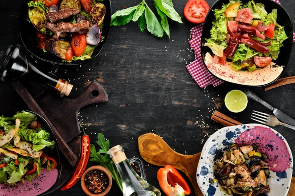 Yemek ve yemeklerin arka planı. Et ve balık yemekleri ve salata. Ahşap bir arka planda. Üst görünüm. Metniniz için boş alan.