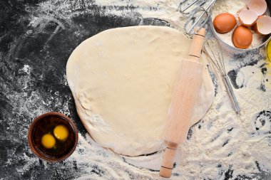 Un hamur hazırlanması arka plan. siyah bir arka planda iğne ve un haddeleme. Üst görünüm. Ücretsiz kopya alanı.