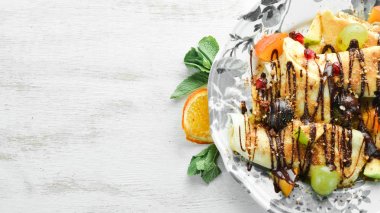 Meyveler ve çikolatayla krep. Tatlı. Ahşap bir arka planda. Üst görünüm. Metniniz için boş alan.