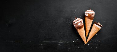 Siyah bir arka planda bir waffle bardağın içinde dondurma. Üst görünüm. Ücretsiz kopya alanı.