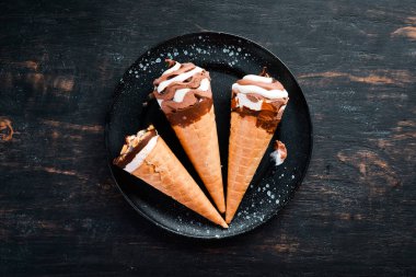 Siyah bir arka planda bir waffle bardağın içinde dondurma. Üst görünüm. Ücretsiz kopya alanı.