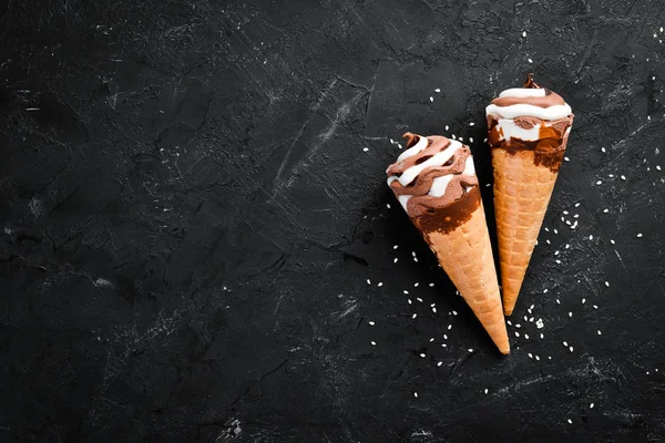 Ice cream in a waffle cup on a black background. Top view. Free copy space.