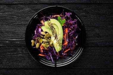Mor lahana, havuç, avokado ve Kabak tohumları salatası. Üst görünüm. Beyaz ahşap bir arka planda. Ücretsiz kopya alanı.