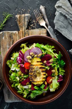 Salata. Marul, pancar, avokado ve Kabak tohumları. Üst görünüm. Siyah bir arka planda. Ücretsiz kopya alanı.