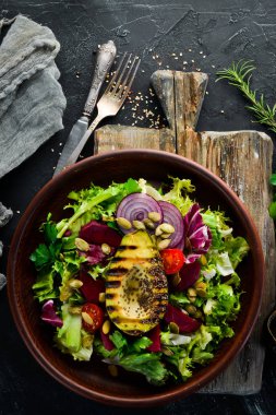 Salata. Marul, pancar, avokado ve Kabak tohumları. Üst görünüm. Siyah bir arka planda. Ücretsiz kopya alanı.