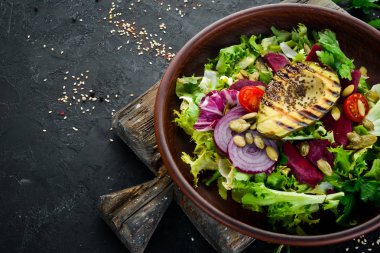 Salata. Marul, pancar, avokado ve Kabak tohumları. Üst görünüm. Siyah bir arka planda. Ücretsiz kopya alanı.