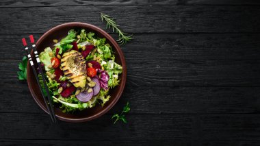 Salata. Marul, pancar, avokado ve Kabak tohumları. Üst görünüm. Siyah bir arka planda. Ücretsiz kopya alanı.