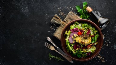 Salata. Marul, pancar, avokado ve Kabak tohumları. Üst görünüm. Siyah bir arka planda. Ücretsiz kopya alanı.