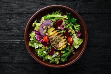 Salata. Marul, pancar, avokado ve Kabak tohumları. Üst görünüm. Siyah bir arka planda. Ücretsiz kopya alanı.