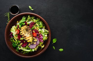 Salata. Marul, pancar, avokado ve Kabak tohumları. Üst görünüm. Siyah bir arka planda. Ücretsiz kopya alanı.