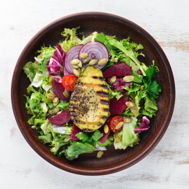 Salata. Marul, pancar, avokado ve Kabak tohumları. Üst görünüm. Siyah bir arka planda. Ücretsiz kopya alanı.