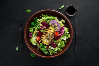 Salata. Marul, pancar, avokado ve Kabak tohumları. Üst görünüm. Siyah bir arka planda. Ücretsiz kopya alanı.