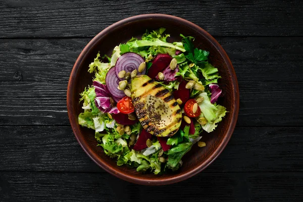 Salata. Marul, pancar, avokado ve Kabak tohumları. Üst görünüm. Siyah bir arka planda. Ücretsiz kopya alanı.