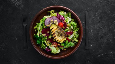 Salata. Marul, pancar, avokado ve Kabak tohumları. Üst görünüm. Siyah bir arka planda. Ücretsiz kopya alanı.