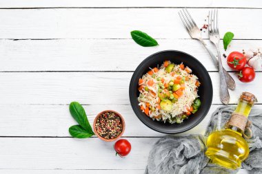 Bir tabak içinde sebzeli risotto. Pirinç. Eski arka planda. Üst görünüm. Metniniz için boş alan.