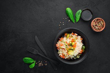 Bir tabak içinde sebzeli risotto. Pirinç. Eski arka planda. Üst görünüm. Metniniz için boş alan.