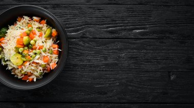 Bir tabak içinde sebzeli risotto. Pirinç. Eski arka planda. Üst görünüm. Metniniz için boş alan.