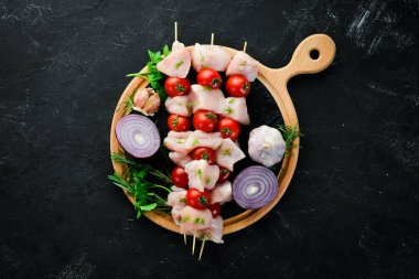 Kiraz domates ile çiğ tavuk şiş kebap. Barbekü. Siyah taş arka planda. Üst görünüm. Ücretsiz kopya alanı.