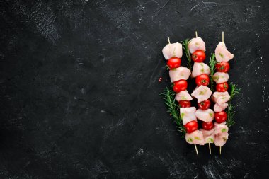 Kiraz domates ile çiğ tavuk şiş kebap. Barbekü. Siyah taş arka planda. Üst görünüm. Ücretsiz kopya alanı.