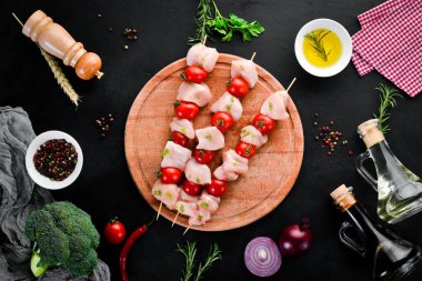 Kiraz domates ile çiğ tavuk şiş kebap. Barbekü. Siyah taş arka planda. Üst görünüm. Ücretsiz kopya alanı.