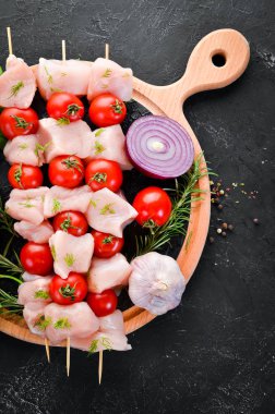 Kiraz domates ile çiğ tavuk şiş kebap. Barbekü. Siyah taş arka planda. Üst görünüm. Ücretsiz kopya alanı.