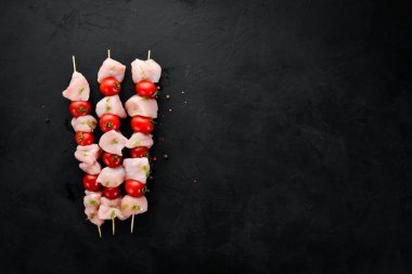 Kiraz domates ile çiğ tavuk şiş kebap. Barbekü. Siyah taş arka planda. Üst görünüm. Ücretsiz kopya alanı.