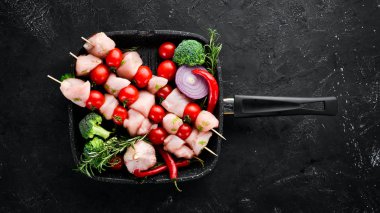Kiraz domates ile çiğ tavuk şiş kebap. Barbekü. Siyah taş arka planda. Üst görünüm. Ücretsiz kopya alanı.