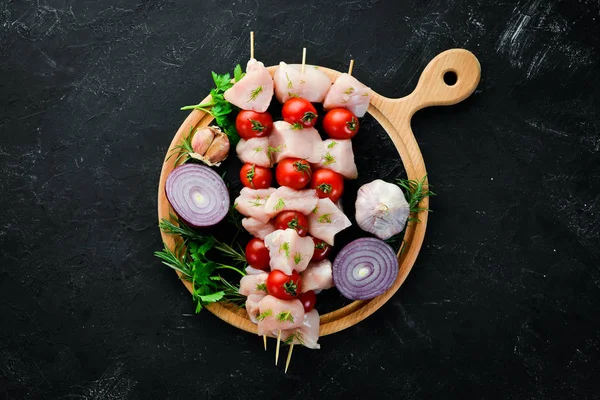 Kiraz domates ile çiğ tavuk şiş kebap. Barbekü. Siyah taş arka planda. Üst görünüm. Ücretsiz kopya alanı.