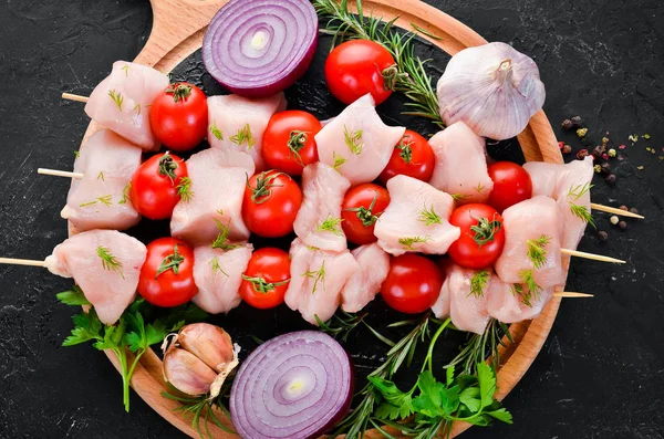 Kiraz domates ile çiğ tavuk şiş kebap. Barbekü. Siyah taş arka planda. Üst görünüm. Ücretsiz kopya alanı.