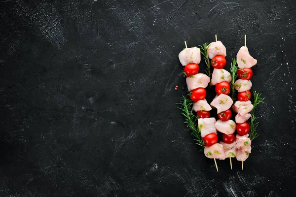 Kiraz domates ile çiğ tavuk şiş kebap. Barbekü. Siyah taş arka planda. Üst görünüm. Ücretsiz kopya alanı.