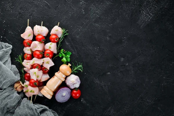 Kiraz domates ile çiğ tavuk şiş kebap. Barbekü. Siyah taş arka planda. Üst görünüm. Ücretsiz kopya alanı.