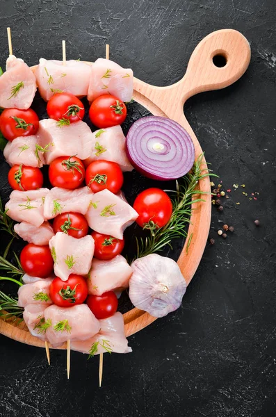 Kiraz domates ile çiğ tavuk şiş kebap. Barbekü. Siyah taş arka planda. Üst görünüm. Ücretsiz kopya alanı.