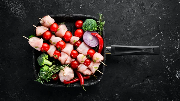 Kiraz domates ile çiğ tavuk şiş kebap. Barbekü. Siyah taş arka planda. Üst görünüm. Ücretsiz kopya alanı.